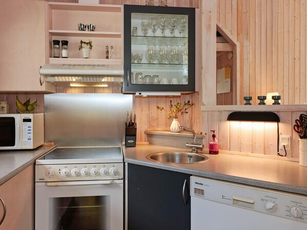 A compact kitchen with a microwave, stove, and dishwasher.