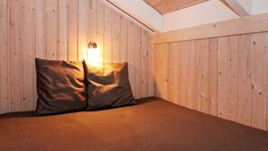 Une pièce avec un plafond en pente, des murs en bois et un lit avec deux oreillers.