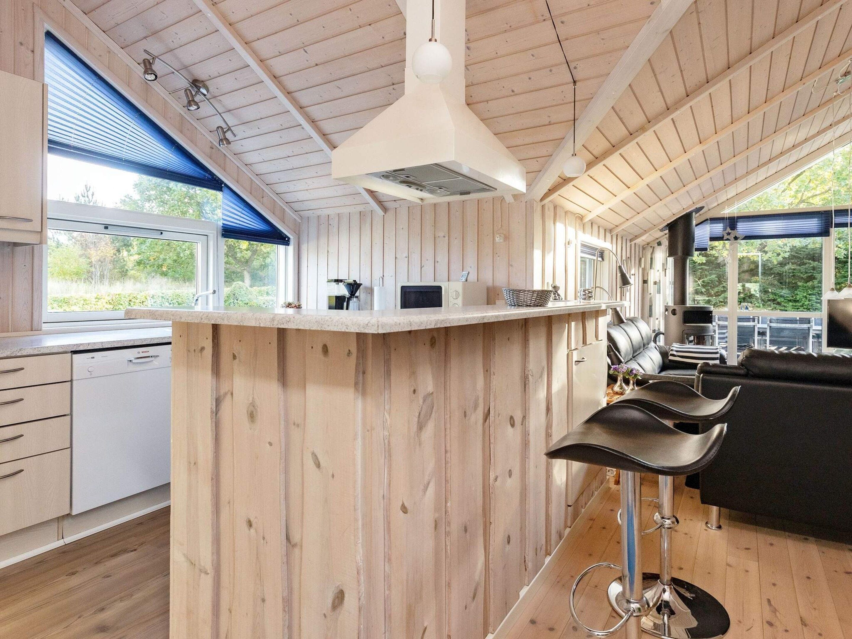 A modern kitchen with wooden paneling, a bar area, and a view of the outdoors.