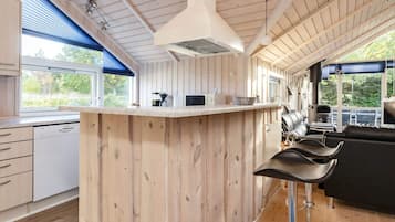 A modern kitchen with wooden paneling, a bar area, and a view of the outdoors.