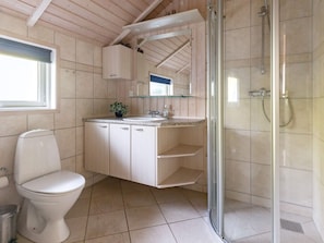 Et badeværelse med toilet, vask og brusebad.