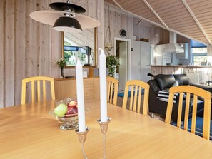 A dining area with a wooden table, chairs, and a candle centerpiece.