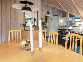 A dining area with a wooden table, chairs, and a candle centerpiece.