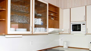 A kitchen with a built-in microwave, a coffee maker, and a sink with a stainless steel basin. - Holiday Home in Otterndorf (Otterndorf)