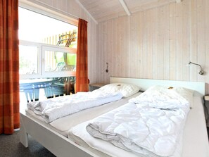 Une chambre d’hôtel avec un grand lit, une fenêtre avec des rideaux et une vue sur le mobilier d’extérieur.