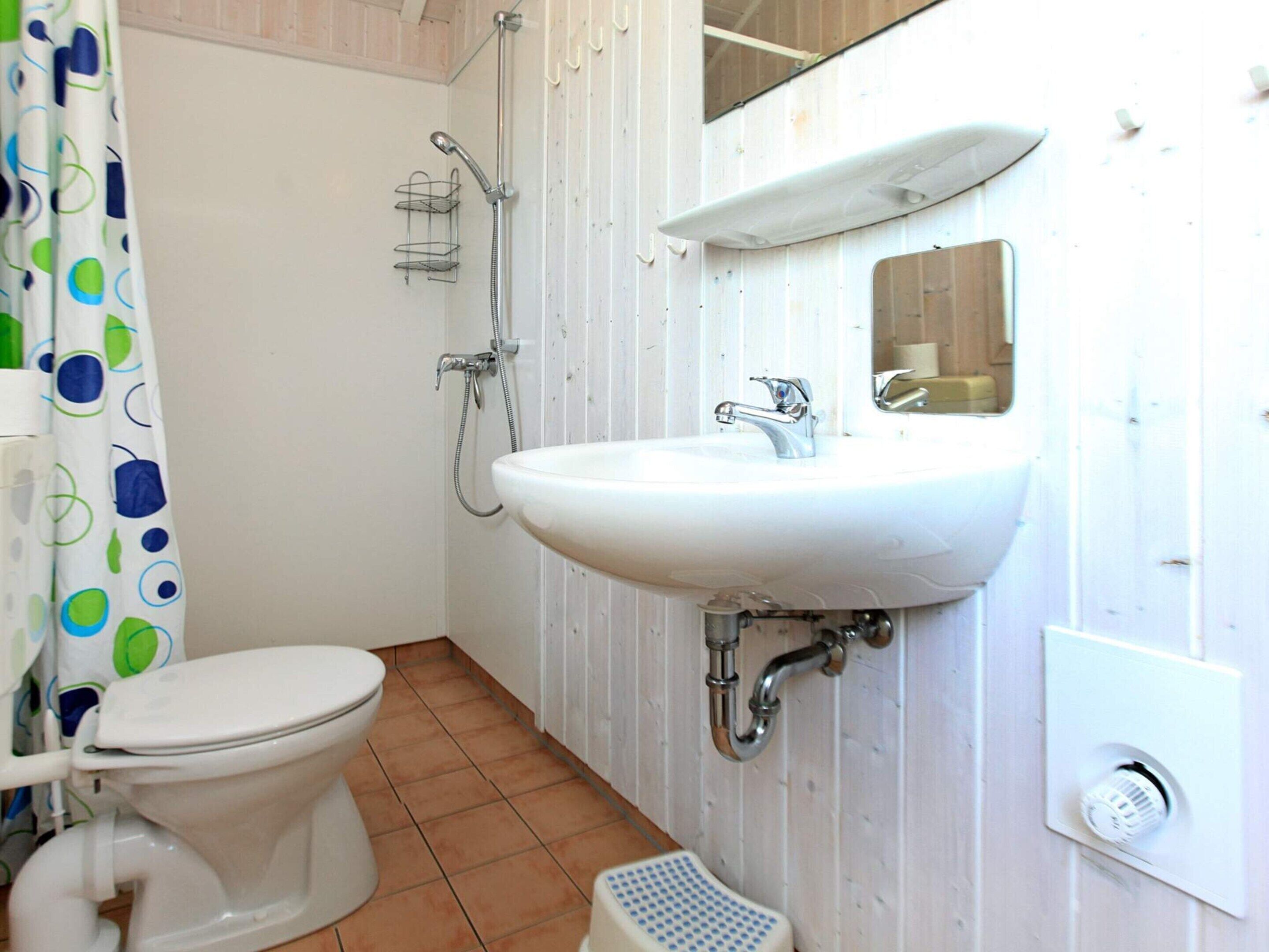 A bathroom with a toilet, a sink, and a shower.