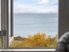 A view through a window of a coastal landscape with a body of water and autumn foliage. - Lovely Holiday Home in AsnÃ¦s near Sea (Asnaes)