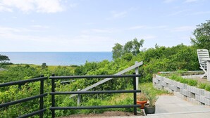 A coastal view with a paved pathway leading to a railing overlooking the sea. - Lovely Holiday Home in AsnÃ¦s near Sea (Asnaes)