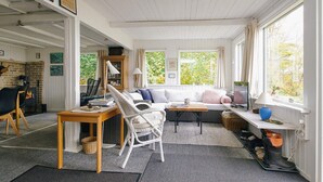 A cozy living room with a sofa, chairs, a table, and a fireplace. - Lovely Holiday Home in AsnÃ¦s near Sea (Asnaes)