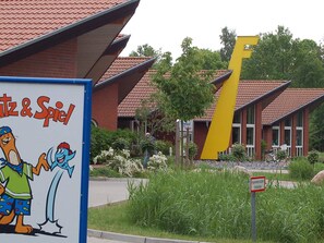A building with a distinctive yellow structure, a sign with cartoon characters, and a sign indicating a fire hydrant zone.