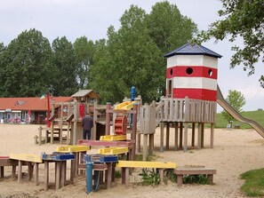 A playground with a slide, climbing structures, and a lookout tower.