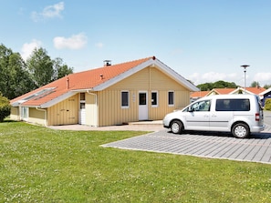 A single-story building with a red-tiled roof, a white van parked in front, and a paved driveway. - Beautiful Holiday Home in Løgstør (Otterndorf)