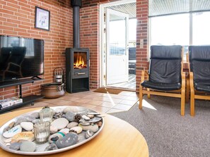 A cozy living room with a fireplace, a television, and a seating area.
