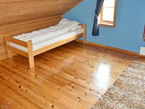 A single wooden bed in a room with wooden flooring and a sloped ceiling. - 6 Person Holiday Home in Norddal (Fjord)