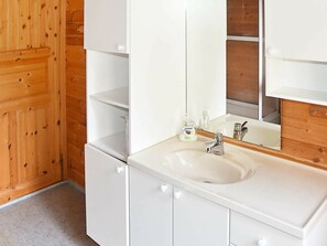 A bathroom with a white sink, a mirror, and a bottle of hand soap. - 6 Person Holiday Home in Norddal (Fjord)