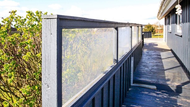 A covered outdoor walkway with a glass enclosure, leading to a building with a white facade and traditional architectural details. - Lovely Holiday Home in Lemvig near Sea (Lemvig)