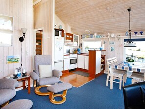 A cozy cabin interior with a kitchenette, a dining area, and a seating area with a view. - Lovely Holiday Home in Lemvig near Sea (Lemvig)