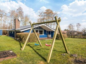 A wooden swing set in a backyard with a house in the background. - Superb Holiday Home in Hemmet near Sea (Hemmet)