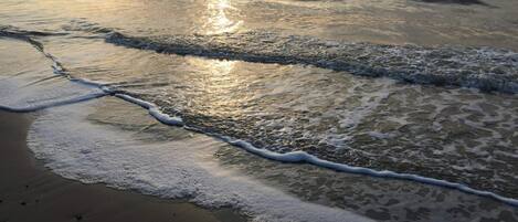 A beach with waves gently lapping onto the shore.