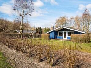 A modern blue house with a large window and a door, surrounded by a well-maintained garden and a hedge. - Superb Holiday Home in Hemmet near Sea (Hemmet)