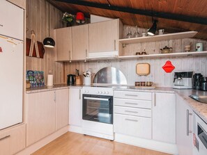 A modern kitchen with white cabinets, a stove, oven, and a coffee machine. - Superb Holiday Home in Hemmet near Sea (Hemmet)
