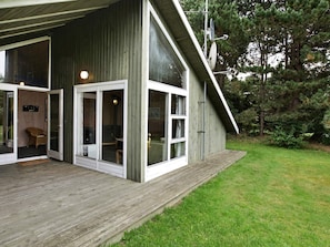 A modern building with large windows and a wooden deck.