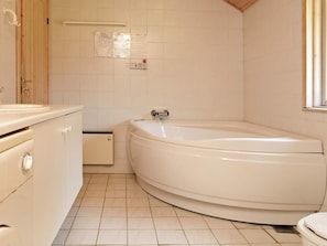Un baño con bañera, inodoro y lavamanos.