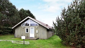 En liten, envåningshus av trä med ett sadeltak, en ytterdörr och en liten veranda.