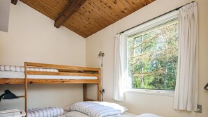 A room with bunk beds, a desk, and a window with curtains. - 5 Person Holiday Home in Hojslev (Hojslev)
