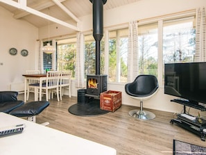 Una sala de estar acogedora con chimenea, comedor y televisor.