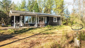 A modern cabin with a covered patio, large windows, and a natural forest backdrop. - 5 Person Holiday Home in Hojslev (Hojslev)