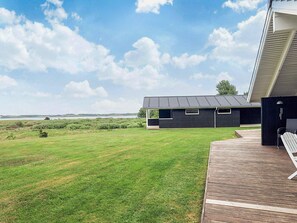 A modern building with a flat roof and a large grassy yard. - 5 Star Holiday Home in Hojslev (Hojslev)