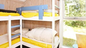 A bunk bed room with a window view.