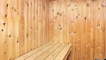 A wooden sauna room with a bench and a bench on the right side.