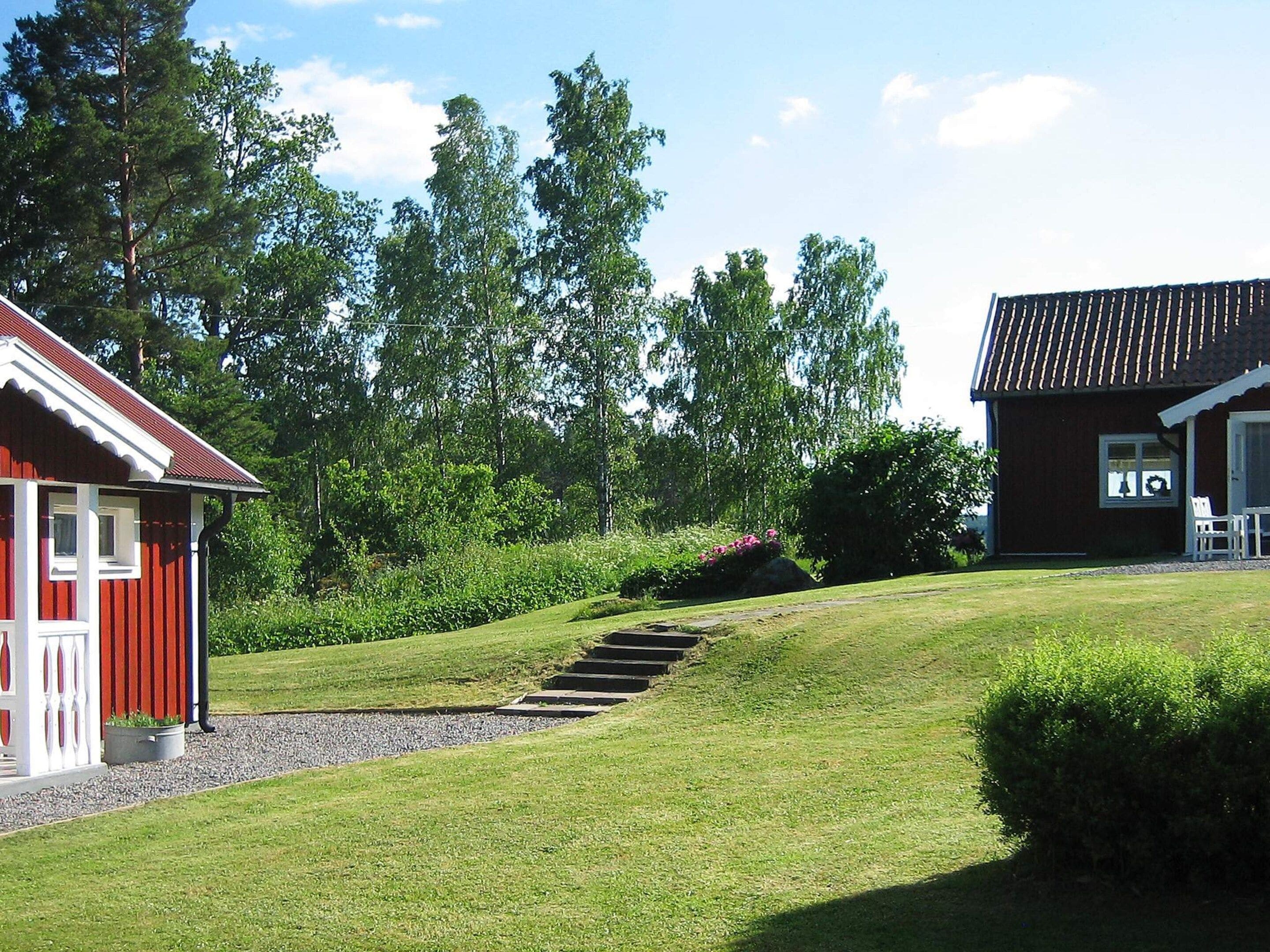 Een rood gebouw met een witte veranda en een stenen trap naar een gazon.