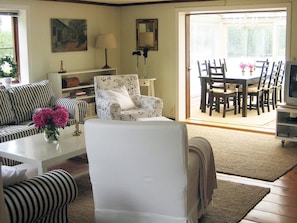 A living room with a sofa, a chair, a coffee table, and a dining area with a table and chairs. - Holiday Home in Åtvidaberg (Atvidaberg)
