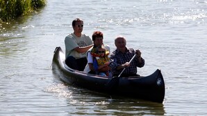 Um grupo de pessoas em um barco a remo em águas calmas.