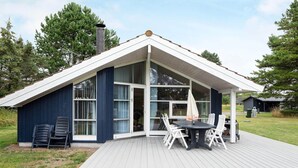 A modern house with a large deck, a covered patio, and a chimney. - 4 Star Holiday Home in Rodby (Rodby)