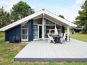 A modern house with a large deck, a covered patio, and a chimney. - 4 Star Holiday Home in Rodby (Rodby)