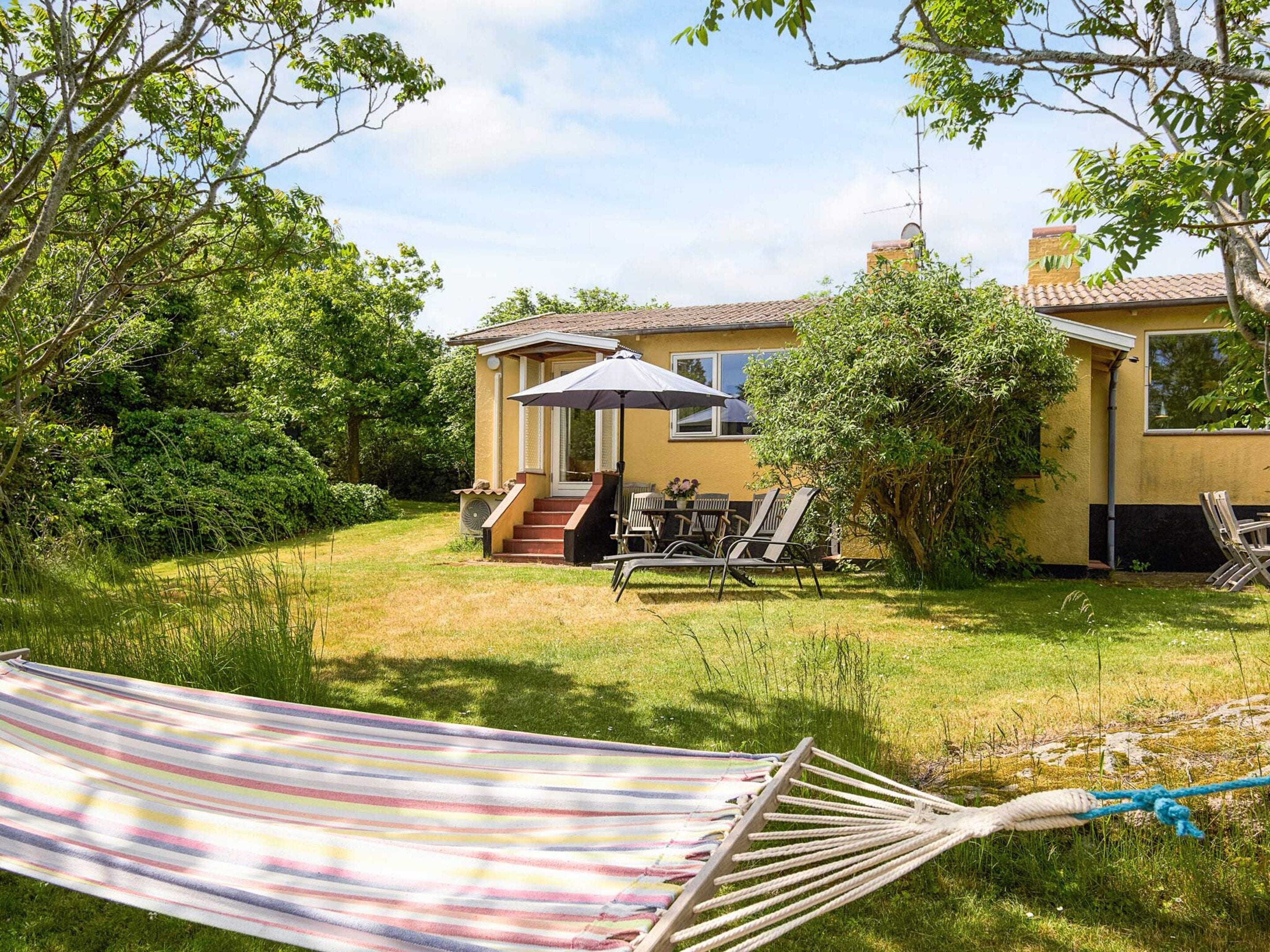 A house with a patio, outdoor furniture, and a hammock.