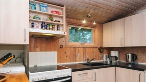 A compact kitchen with wooden cabinets, a stove, and a sink. - 6 Person Holiday Home in Glesborg (Glesborg)