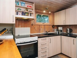 Una cocina pequeña con armarios de madera, una estufa y un lavabo.