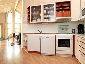 Una cocina compacta con lavavajillas, horno y armarios de madera.
