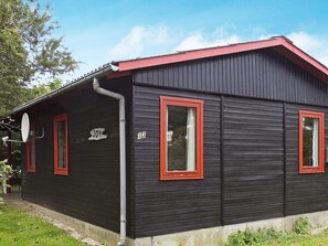 A black wooden building with red window frames and a number '13' on the side.