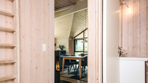 Un interior de madera con comedor, chimenea y un lavamanos.