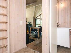 A wooden interior with a dining area, a fireplace, and a sink. - 4 Star Holiday Home in Hemmet (Hemmet)