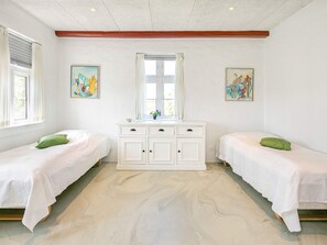 A room with two beds, a white dresser, and artwork on the walls. - 4 Star Holiday Home in Ulfborg (Ulfborg)