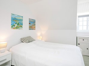 A bedroom with a bed, bedside lamps, and two wall-mounted paintings. - 4 Star Holiday Home in Ulfborg (Ulfborg)