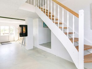 A staircase with white railings and wooden steps, leading to an upper floor.