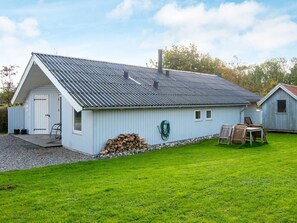 Ein eingeschossiges Gebäude mit einem geneigten Dach, einer Tür und einem kleinen Fenster.